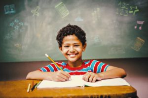 Boy writing and smiling