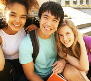 Teenagers smiling outside.