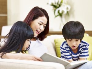 Image of a mother reading with her daughter and son.